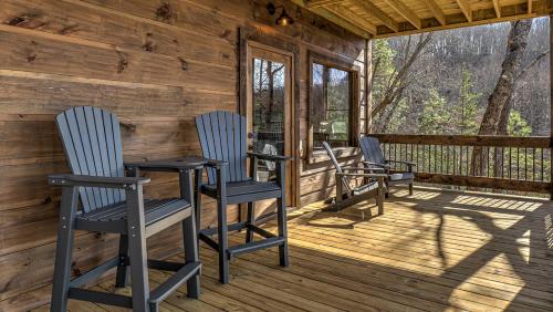 four chairs and a table on the porch of a cabin at Clocking Inn in Mineral Bluff