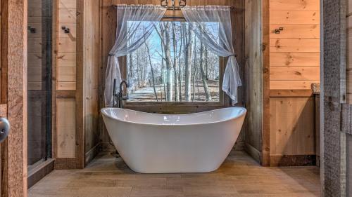 a white bath tub in a room with a window at Clocking Inn in Mineral Bluff