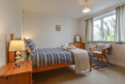 1 dormitorio con cama, escritorio y silla en The Quillet en Penzance