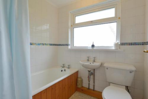ein Badezimmer mit Toilette und Waschbecken und einem Fenster in der Unterkunft The Quillet in Penzance