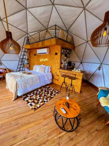 a bedroom in a tent with a bed and a table at Glamping Atmosphera in Cambará