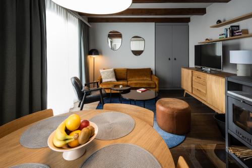 een woonkamer met een tafel met een fruitschaal erop bij Exklusive Seeappartements beim Elfenhaus in Grundlsee