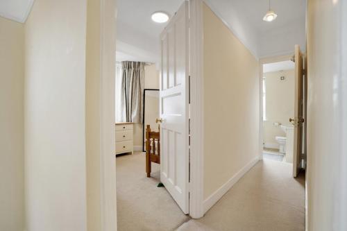 un corridoio con porta che conduce al bagno di 5 bed with parking and large private garden a Finchley