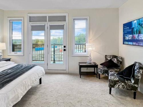 um quarto com uma cama, uma cadeira e janelas em Luxury Family Home em Markham
