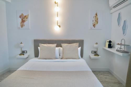 a white bedroom with a large bed with white walls at Aldara Sitges in Sitges