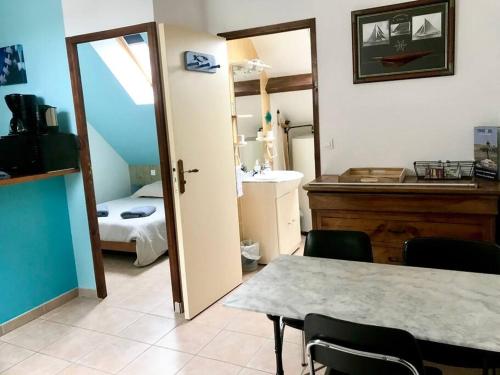 een kamer met een tafel en een badkamer met een slaapkamer bij Océan · Gite rural - Herbignac, La Roche-Bernard in Herbignac