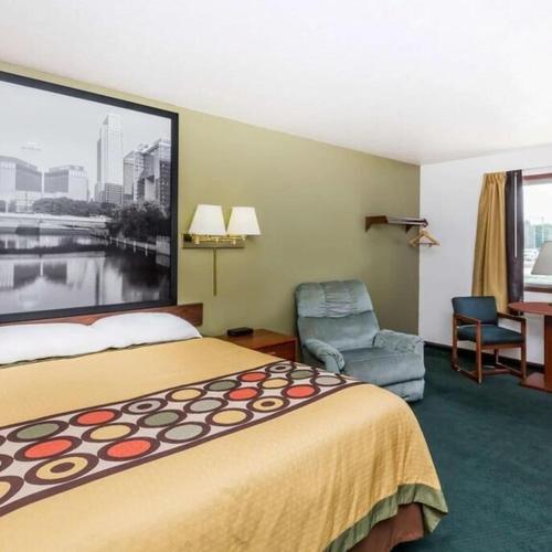 a hotel room with a bed and a chair at AINSWORTHINN in Ainsworth