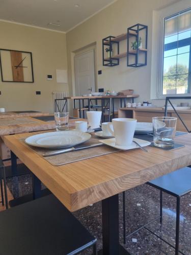 a wooden table with plates and glasses on it at B&B La Magnolia in Savona