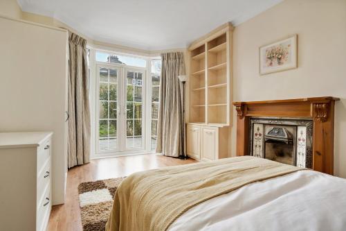 a bedroom with a bed and a fireplace at 5 bed with parking and large private garden in Finchley