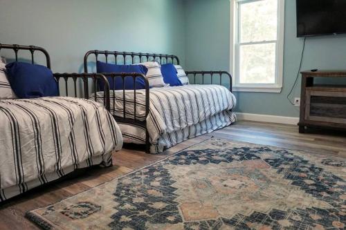 a bedroom with two beds and a rug and a window at Majestic Lakeview Duplex Apt for 8! Fully furnished and ready for your getaway! in Tilton