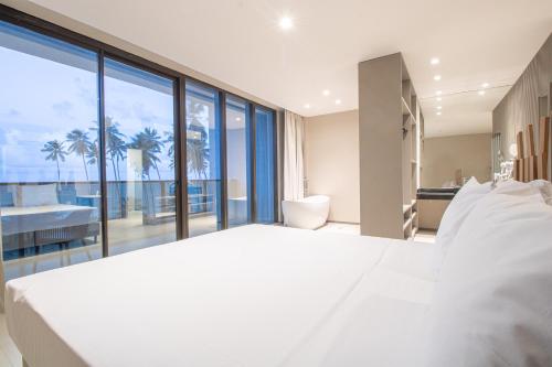 Maceio Mar Resort All Inclusive في ماسيو: غرفة نوم بيضاء كبيرة مطلة على المحيط