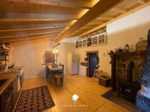 a large room with a kitchen with a fireplace at Casa do Bernardino in Cabril