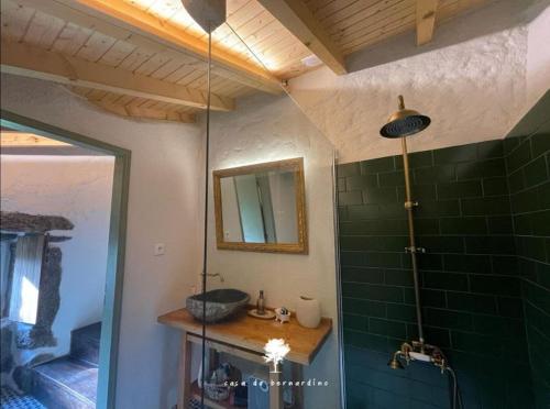 a bathroom with a shower with a sink and a mirror at Casa do Bernardino in Cabril