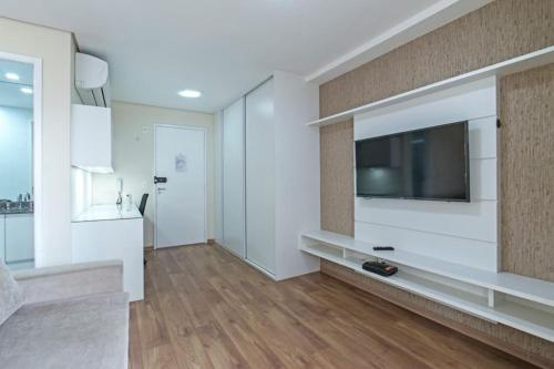 a living room with a flat screen tv on a wall at Studio Business Alto da Boa Vista - Perto do Consulado e Transamérica in Sao Paulo