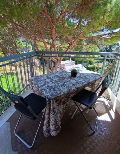 einen Tisch und Stühle auf einem Balkon mit einem Baum in der Unterkunft [Forti Genova-Free Parking] Castellaccio Apartment 2 in Genua
