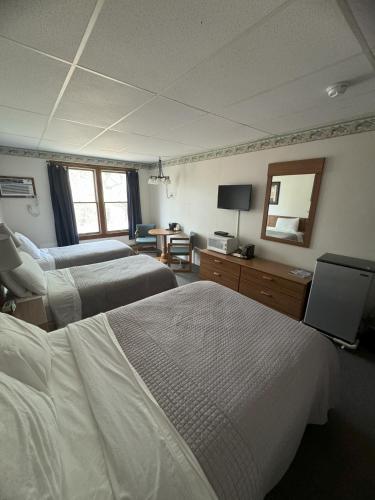 a hotel room with two beds and a mirror at Lake Ontario Motel & Inn in Newfane