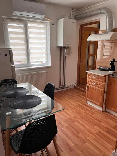 a kitchen with a glass table and some chairs at Medeea in Zalău
