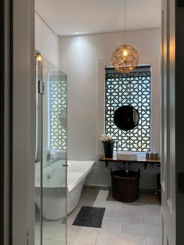 a bathroom with a tub and a glass shower at Villa on Main in Antwerp