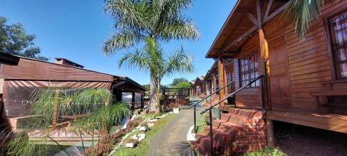 a path between two buildings with a palm tree at Terra Iguazú Cabañas in Puerto Iguazú