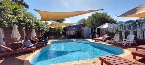 a swimming pool with people sitting in chairs around it at Terra Iguazú Cabañas in Puerto Iguazú