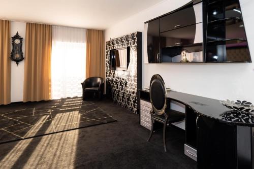 um quarto de hotel com uma secretária, uma mesa e cadeiras em Titan Centrum Apartman em Nyíregyháza