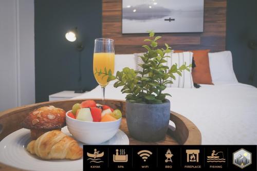 a tray with a bowl of fruit and a glass of orange juice at Chalet Le Convivial Tremblant in Lac-Superieur