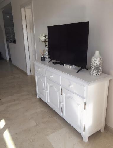 a white dresser with a television on top of it at Casa Villamartin Plaza Apartment in Villacosta