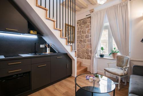 a living room with a table and a staircase at Old Town City Center Apartments in Dubrovnik