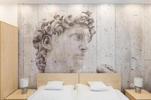 a bedroom with a mural of a head on the wall at Titan Centrum Apartman in Nyíregyháza