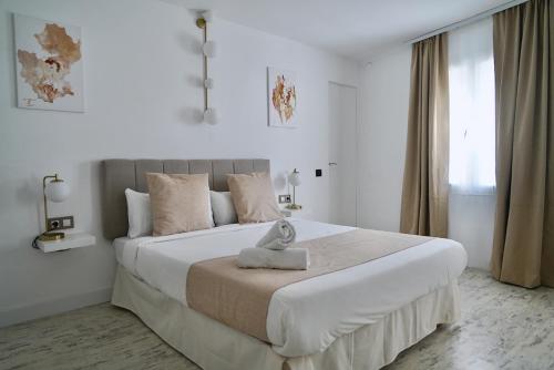 - une chambre blanche avec un grand lit dans l'établissement Aldara Sitges, à Sitges