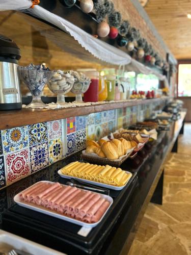 ein Buffet mit Brot, Würstchen und Gebäck in der Unterkunft Yannai Chalé Praia in Ilhabela