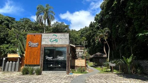 una tienda con un cartel al costado de una carretera en Yannai Chalé Praia en Ilhabela