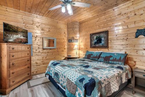 a bedroom with a bed and a ceiling fan at Private! Hot Tub, Views, & Games in Sevierville