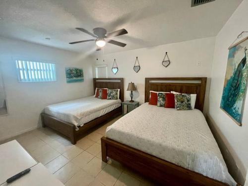 a bedroom with two beds and a ceiling fan at Lakefront Duplex with Pontoon Boat 2 Bedroom Home in Mount Dora