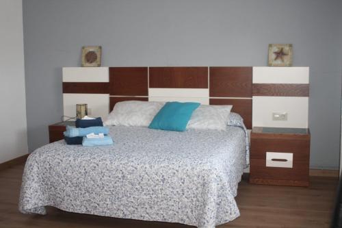 um quarto com uma cama e uma cabeceira em madeira em A casa de Dora da Estrada em A Estrada