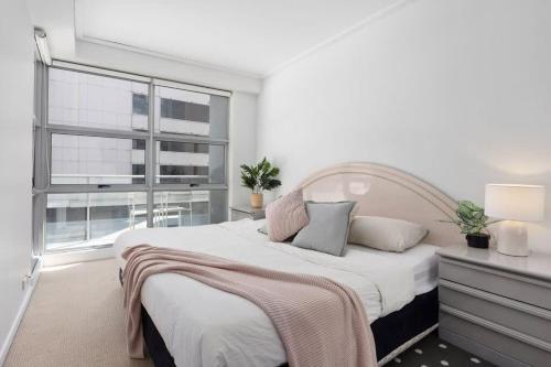 una camera da letto con un letto grande e una finestra di A Comfy 2BR Apt for 7 Next to Darling Harbour a Sydney