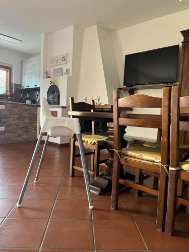 een eetkamer met een tafel en stoelen en een televisie bij La Casa Sul Lago in Passignano sul Trasimeno