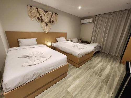 a hotel room with two beds with white sheets at Diyar Pyramids Inn in Cairo