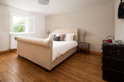 a bedroom with a large white bed and a window at The Old School in Edlingham