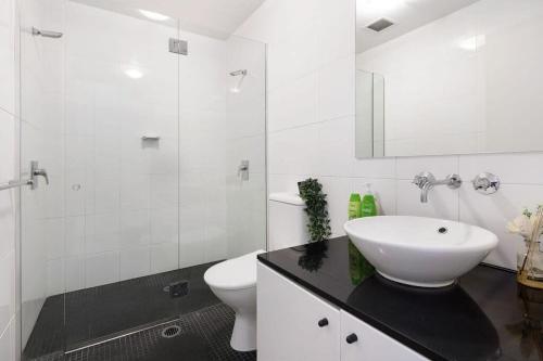a white bathroom with a sink and a toilet at A Stylish & Bright Suite Next to Darling Harbour in Sydney