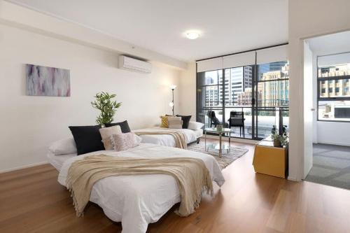 a bedroom with two beds and a living room at A Stylish & Bright Suite Next to Darling Harbour in Sydney