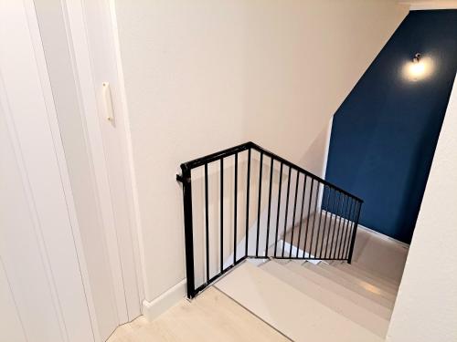 a stairwell with a black railing and a blue wall at Anninnìa Guest House B&B - GhiIarza in Ghilarza