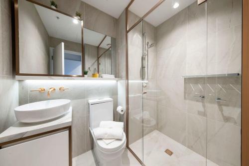 uma casa de banho com um WC, um lavatório e um chuveiro em A Lux & Cozy 2BR Apt in the Heart of Chapel Street em Melbourne