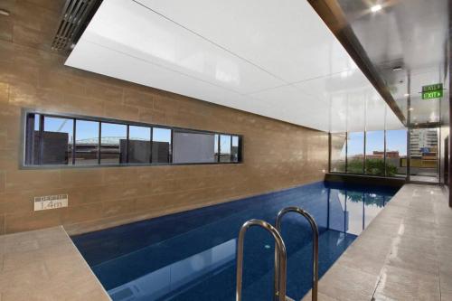 uma piscina num edifício com uma grande janela em Cozy 2BR Apt Next to Southern Cross FREE Parking em Melbourne