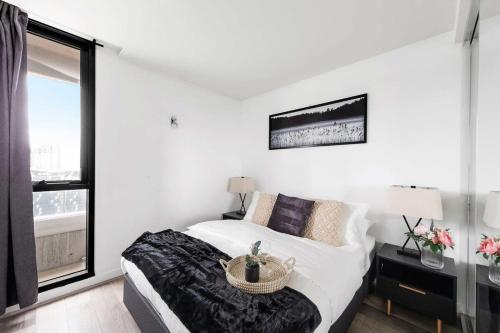 um quarto branco com uma cama e uma janela em Cozy 2BR Apt Next to Southern Cross FREE Parking em Melbourne