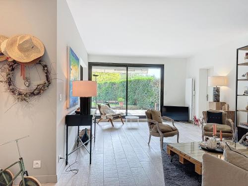 un salon avec un canapé et une table dans l'établissement Garden's YourHostHelper, à Deauville