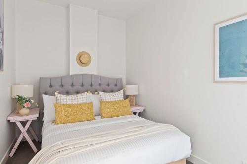 a bedroom with a large bed with yellow pillows at A Cozy 2BR Apt on Collins Near Flinders Station in Melbourne