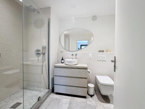 une salle de bain avec un lavabo, des toilettes et un miroir dans l'établissement Garden's YourHostHelper, à Deauville