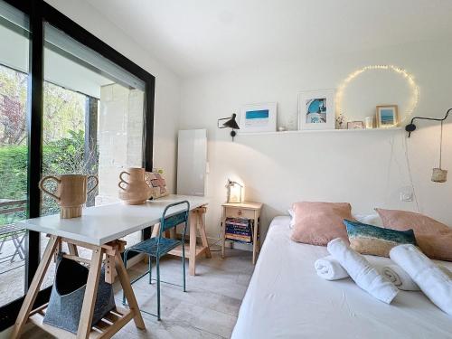 Cette chambre comprend un lit, une table et un bureau. dans l'établissement Garden's YourHostHelper, à Deauville