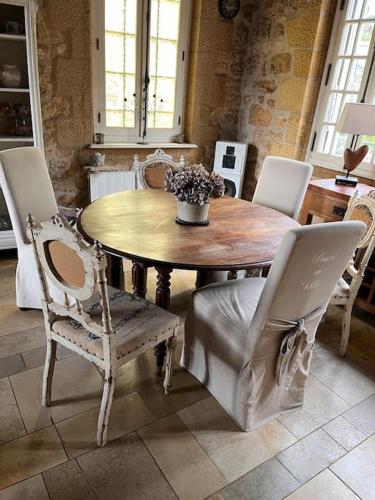 une salle à manger avec une table et des chaises en bois dans l'établissement La périgourdine et son spa, à Saint-Cyprien